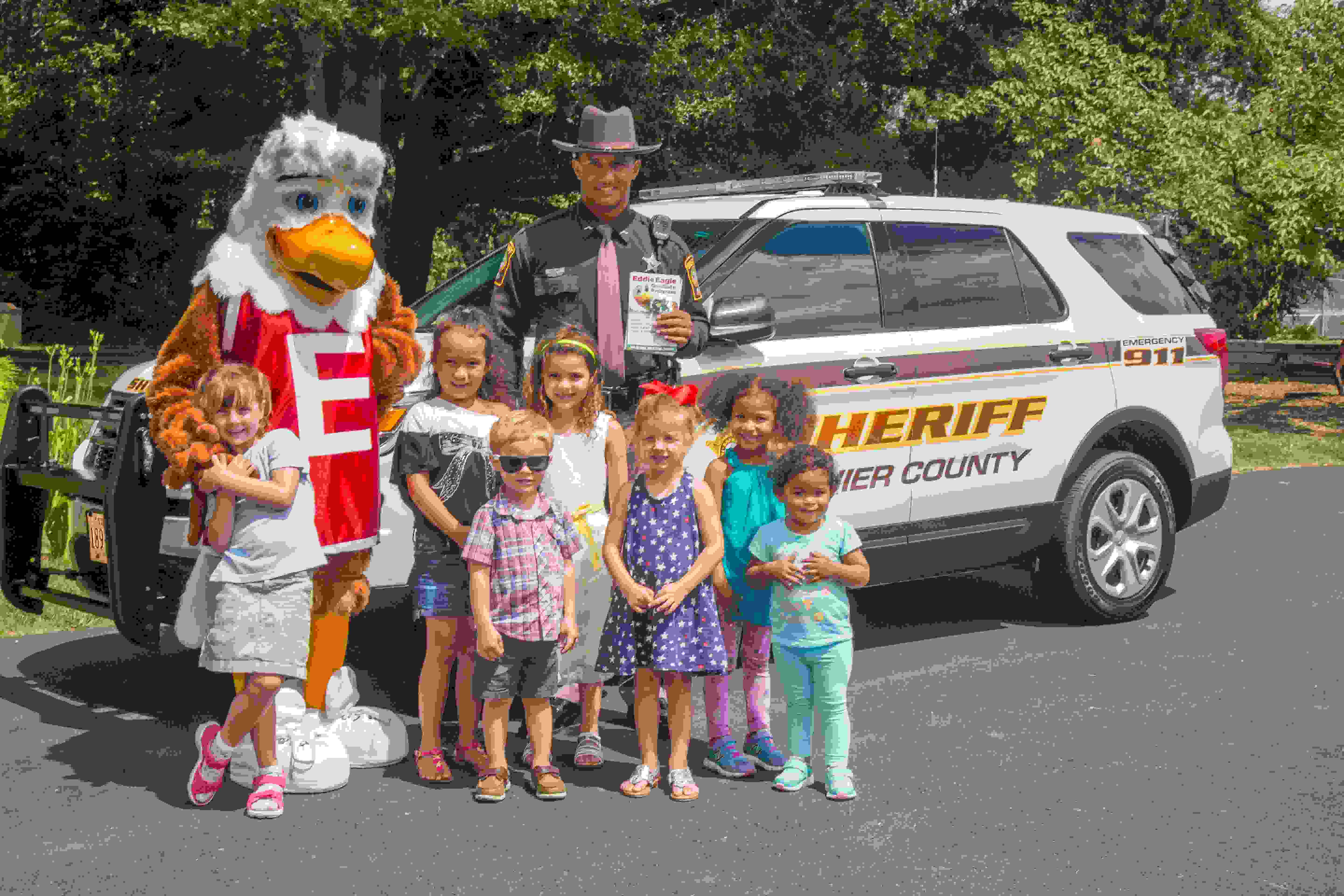 Eddie Eagle Mascot With Children and a Sheriff Outside Standing in Front of a Sheriff Vehicle