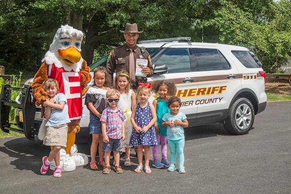 Eddie Eagle Mascot With Children and a Sheriff Outside Standing in Front of a Sheriff Vehicle